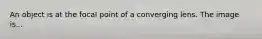 An object is at the focal point of a converging lens. The image is...