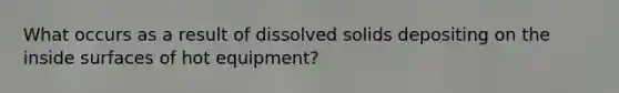 What occurs as a result of dissolved solids depositing on the inside surfaces of hot equipment?