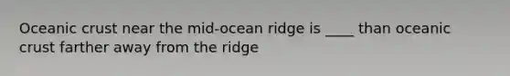 Oceanic crust near the mid-ocean ridge is ____ than oceanic crust farther away from the ridge