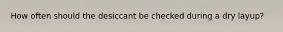 How often should the desiccant be checked during a dry layup?