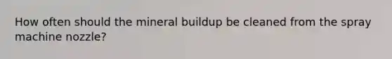 How often should the mineral buildup be cleaned from the spray machine nozzle?