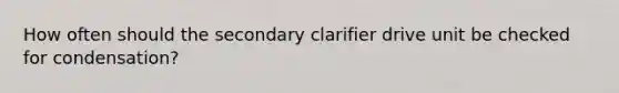 How often should the secondary clarifier drive unit be checked for condensation?