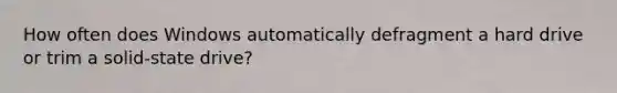 How often does Windows automatically defragment a hard drive or trim a solid-state drive?