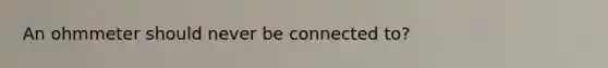 An ohmmeter should never be connected to?