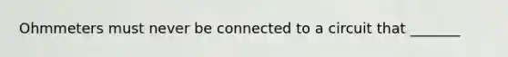 Ohmmeters must never be connected to a circuit that _______