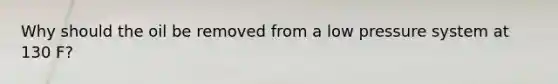 Why should the oil be removed from a low pressure system at 130 F?