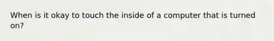 When is it okay to touch the inside of a computer that is turned on?