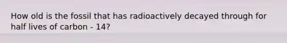 How old is the fossil that has radioactively decayed through for half lives of carbon - 14?