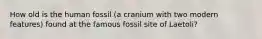 How old is the human fossil (a cranium with two modern features) found at the famous fossil site of Laetoli?