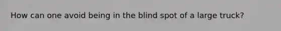 How can one avoid being in the blind spot of a large truck?