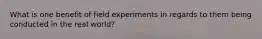 What is one benefit of field experiments in regards to them being conducted in the real world?