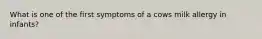 What is one of the first symptoms of a cows milk allergy in infants?