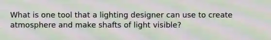 What is one tool that a lighting designer can use to create atmosphere and make shafts of light visible?