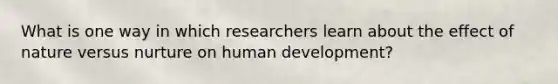 What is one way in which researchers learn about the effect of nature versus nurture on human development?