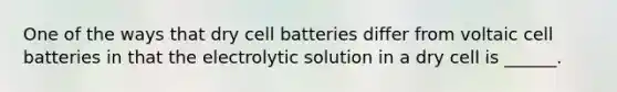 One of the ways that dry cell batteries differ from voltaic cell batteries in that the electrolytic solution in a dry cell is ______.