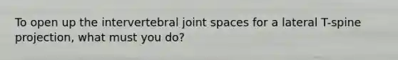 To open up the intervertebral joint spaces for a lateral T-spine projection, what must you do?