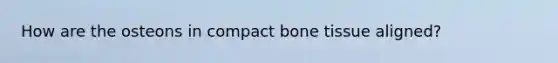 How are the osteons in compact bone tissue aligned?