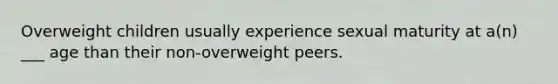 Overweight children usually experience sexual maturity at a(n) ___ age than their non-overweight peers.