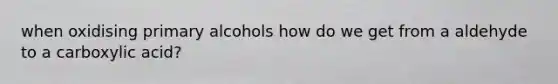 when oxidising primary alcohols how do we get from a aldehyde to a carboxylic acid?