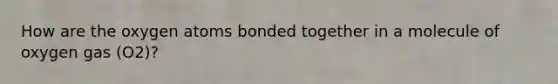 How are the oxygen atoms bonded together in a molecule of oxygen gas (O2)?