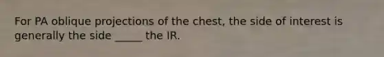 For PA oblique projections of the chest, the side of interest is generally the side _____ the IR.