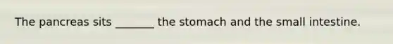 The pancreas sits _______ the stomach and the small intestine.