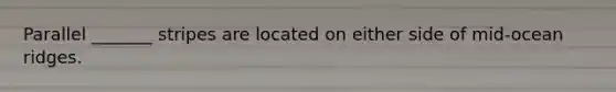 Parallel _______ stripes are located on either side of mid-ocean ridges.
