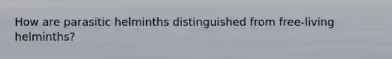 How are parasitic helminths distinguished from free-living helminths?