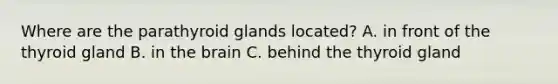Where are the parathyroid glands located? A. in front of the thyroid gland B. in the brain C. behind the thyroid gland