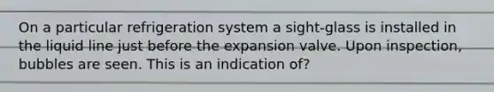 On a particular refrigeration system a sight-glass is installed in the liquid line just before the expansion valve. Upon inspection, bubbles are seen. This is an indication of?