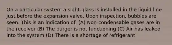 On a particular system a sight-glass is installed in the liquid line just before the expansion valve. Upon inspection, bubbles are seen. This is an indication of: (A) Non-condensable gases are in the receiver (B) The purger is not functioning (C) Air has leaked into the system (D) There is a shortage of refrigerant