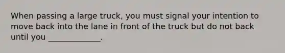 When passing a large truck, you must signal your intention to move back into the lane in front of the truck but do not back until you _____________.