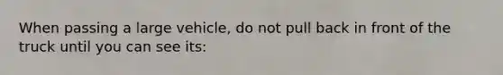 When passing a large vehicle, do not pull back in front of the truck until you can see its: