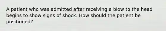 A patient who was admitted after receiving a blow to the head begins to show signs of shock. How should the patient be positioned?