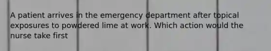 A patient arrives in the emergency department after topical exposures to powdered lime at work. Which action would the nurse take first