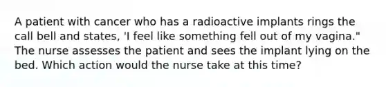 A patient with cancer who has a radioactive implants rings the call bell and states, 'I feel like something fell out of my vagina." The nurse assesses the patient and sees the implant lying on the bed. Which action would the nurse take at this time?