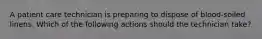 A patient care technician is preparing to dispose of blood-soiled linens. Which of the following actions should the technician take?