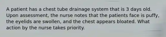 A patient has a chest tube drainage system that is 3 days old. Upon assessment, the nurse notes that the patients face is puffy, the eyelids are swollen, and the chest appears bloated. What action by the nurse takes priority.