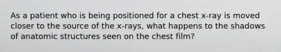 As a patient who is being positioned for a chest x-ray is moved closer to the source of the x-rays, what happens to the shadows of an<a href='https://www.questionai.com/knowledge/kFm8mWrQzt-atomic-structure' class='anchor-knowledge'>atomic structure</a>s seen on the chest film?