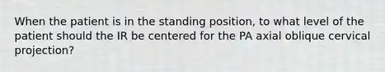 When the patient is in the standing position, to what level of the patient should the IR be centered for the PA axial oblique cervical projection?