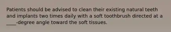 Patients should be advised to clean their existing natural teeth and implants two times daily with a soft toothbrush directed at a ____-degree angle toward the soft tissues.