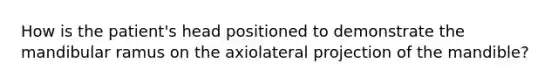 How is the patient's head positioned to demonstrate the mandibular ramus on the axiolateral projection of the mandible?