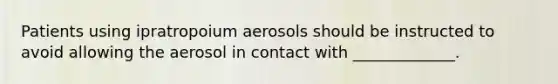 Patients using ipratropoium aerosols should be instructed to avoid allowing the aerosol in contact with _____________.