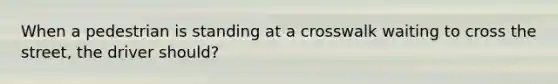 When a pedestrian is standing at a crosswalk waiting to cross the street, the driver should?