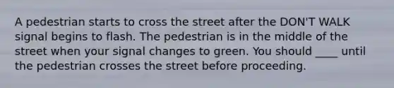 A pedestrian starts to cross the street after the DON'T WALK signal begins to flash. The pedestrian is in the middle of the street when your signal changes to green. You should ____ until the pedestrian crosses the street before proceeding.