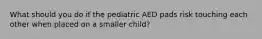 What should you do if the pediatric AED pads risk touching each other when placed on a smaller child?