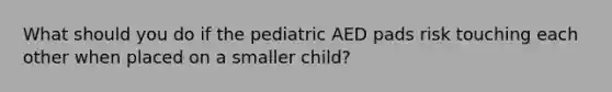 What should you do if the pediatric AED pads risk touching each other when placed on a smaller child?