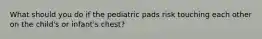 What should you do if the pediatric pads risk touching each other on the child's or infant's chest?