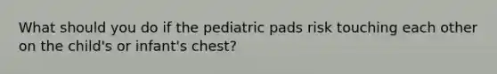 What should you do if the pediatric pads risk touching each other on the child's or infant's chest?