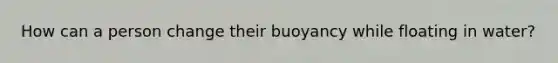 How can a person change their buoyancy while floating in water?